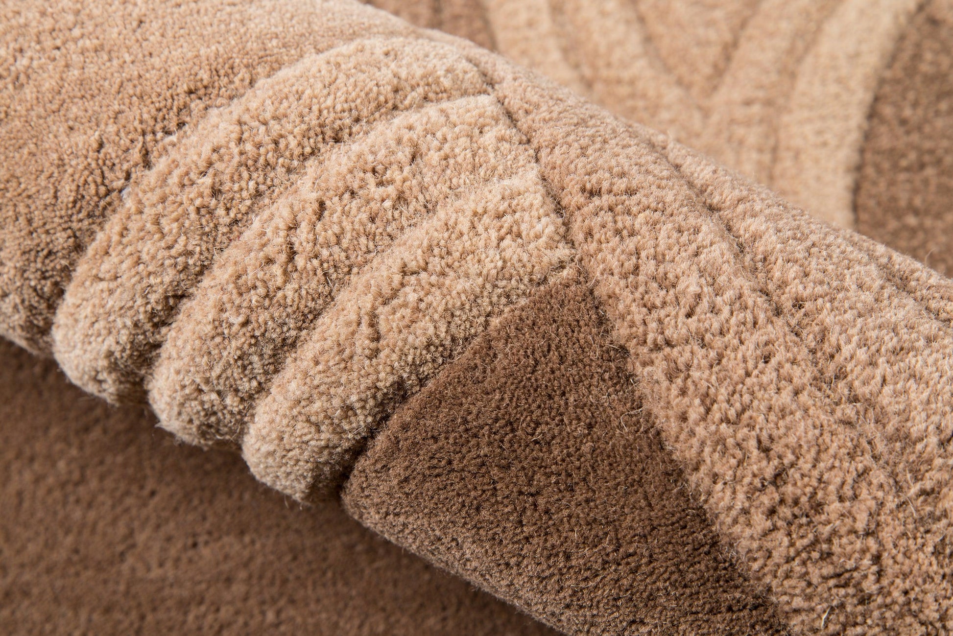 Beige plush shag rug with thick, soft pile, rolled into folds.