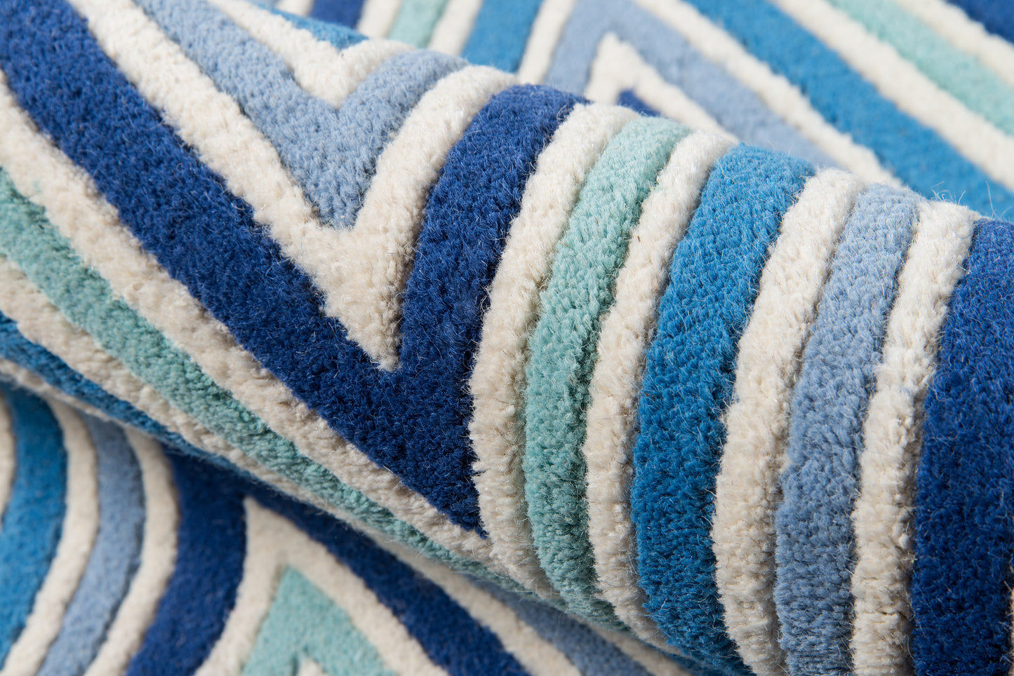 Blue, teal, and white striped rug, 4' x 6', rolled up.