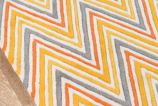 Chevron zigzag rug in orange, yellow and gray on white, retro mid-century style with wood floor edge.