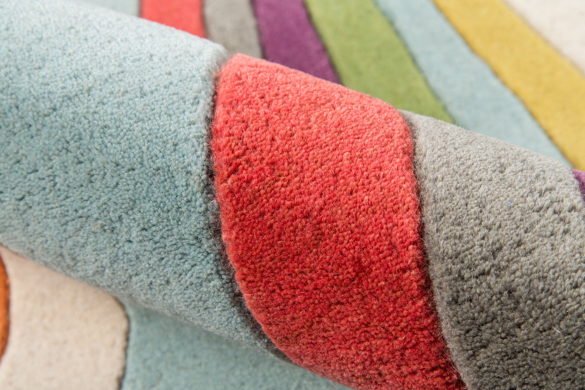 Soft plush multicolor striped rug in blues, red, green and purple with thick pile and rolled edge, 4' x 6'.