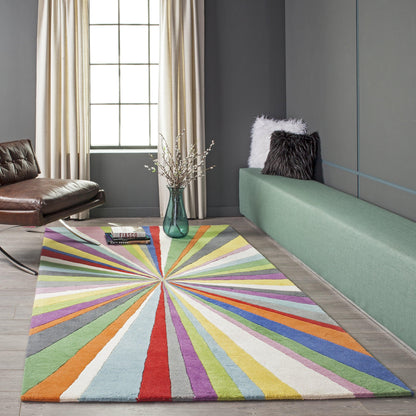 Rectangular rug with multicolor radial stripes in red, blue, green, yellow; living room with mint sofa and brown chair.