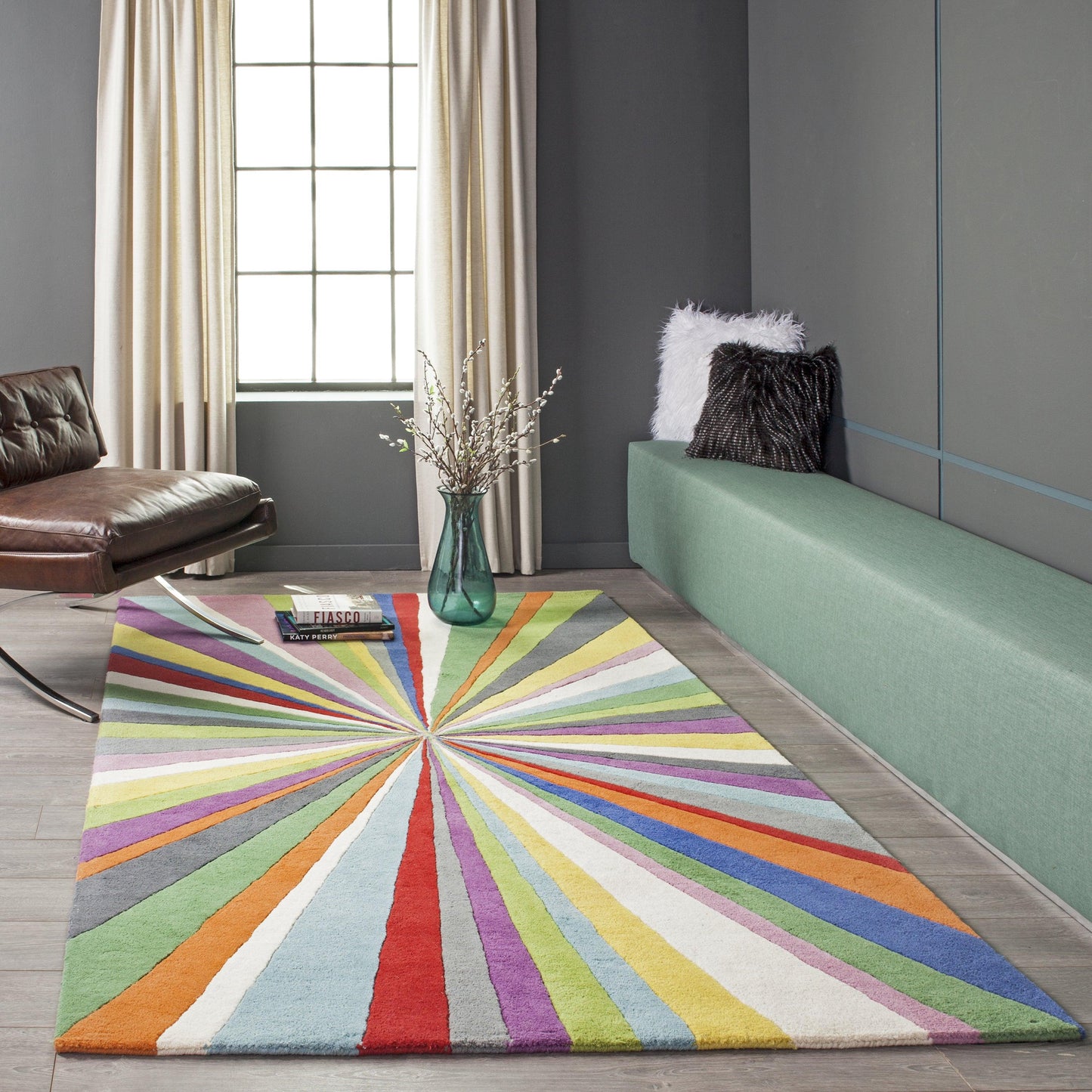 Colorful radial sunburst rug in modern living room with green bench, brown leather chair, and fluffy black/white cushions.
