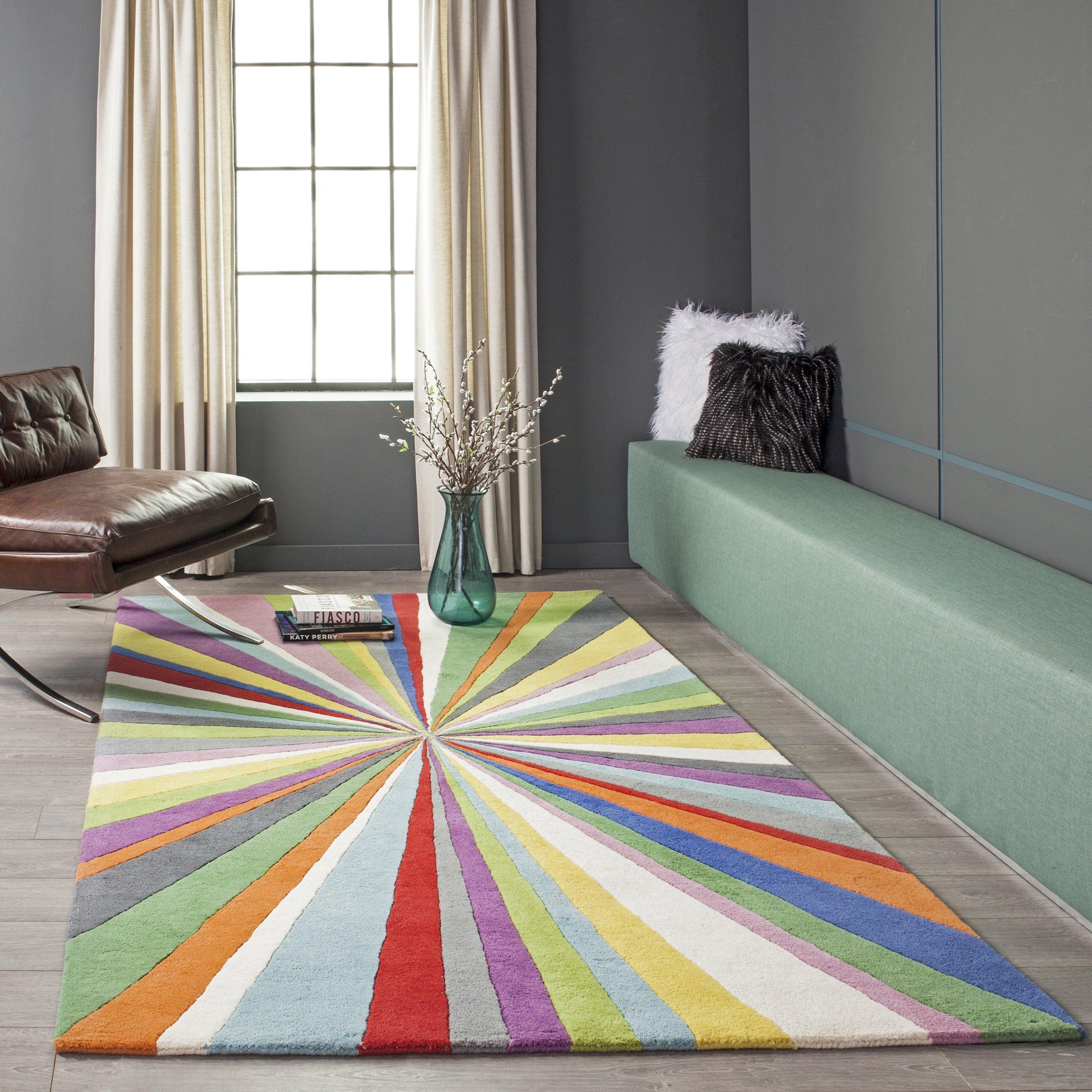 Colorful radial sunburst rug in modern living room with green bench, brown leather chair, and fluffy black/white cushions.
