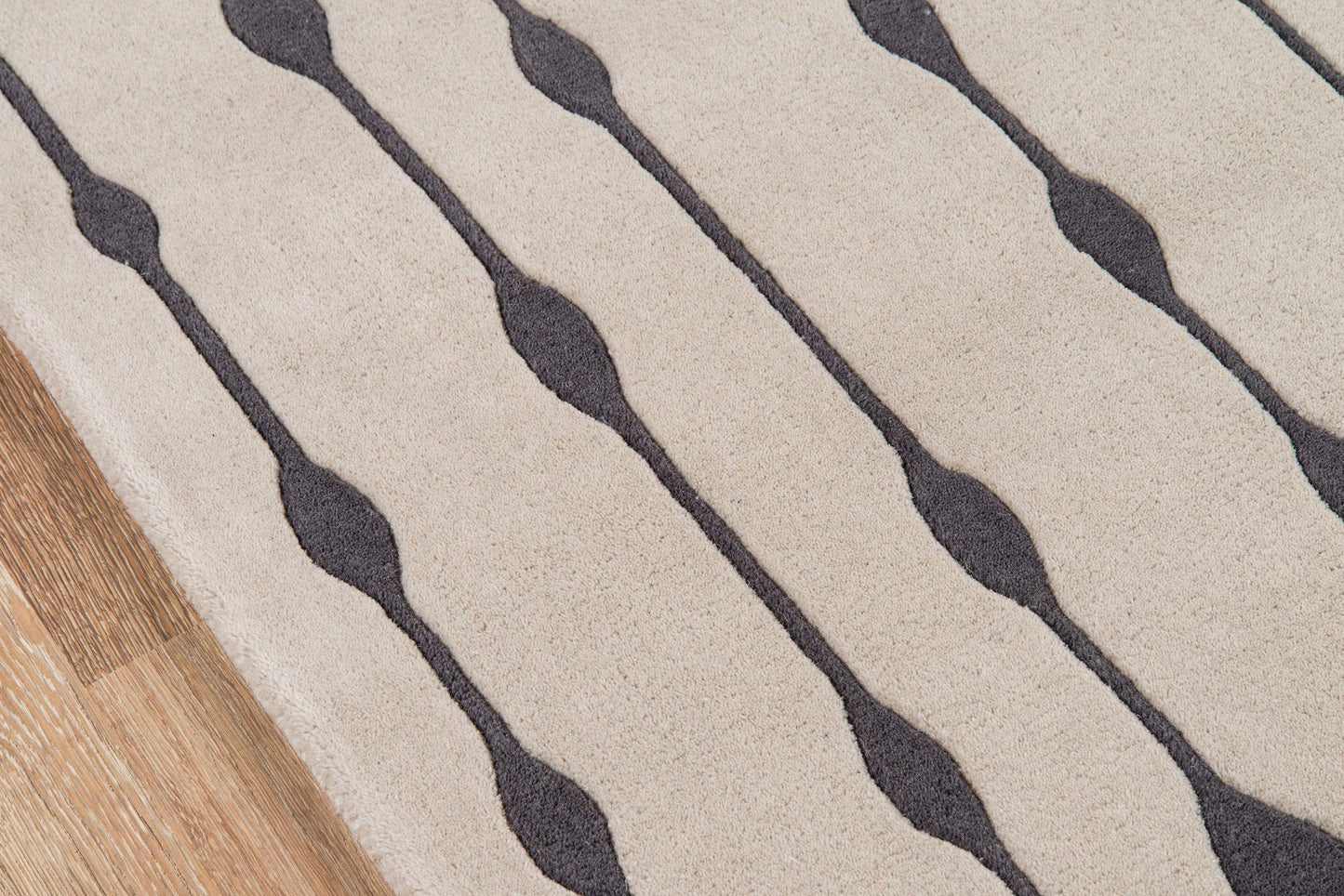 Beige rug with dark gray wavy stripes and a wood floor edge visible.