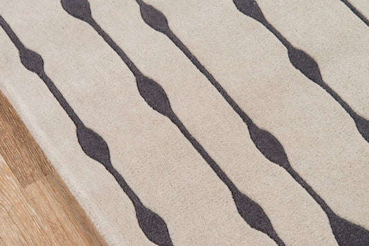 Gray rug with a dark wavy stripe pattern and charcoal curved lines on a light background, wood floor edge visible.