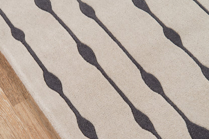 Beige rug with dark gray wavy lines, textured fabric, diagonal stripe pattern & wood floor edge visible.
