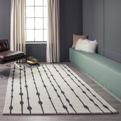 Rectangular cream rug with dark gray vertical dotted stripes; modern living room with mint green bench, beige curtains and brown leather chair.