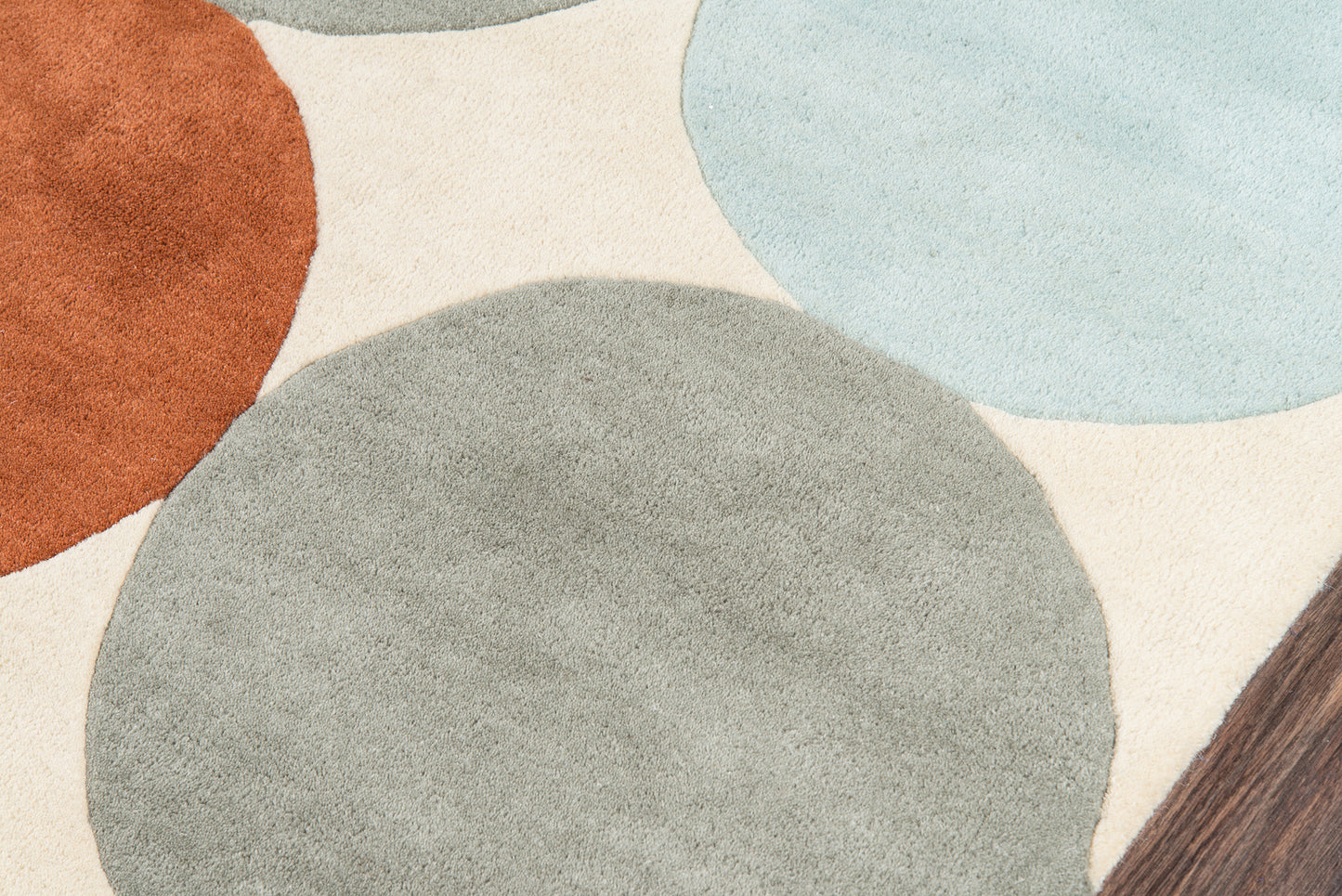 Abstract circular-pattern area rug with orange, gray, and light blue disks on beige background.