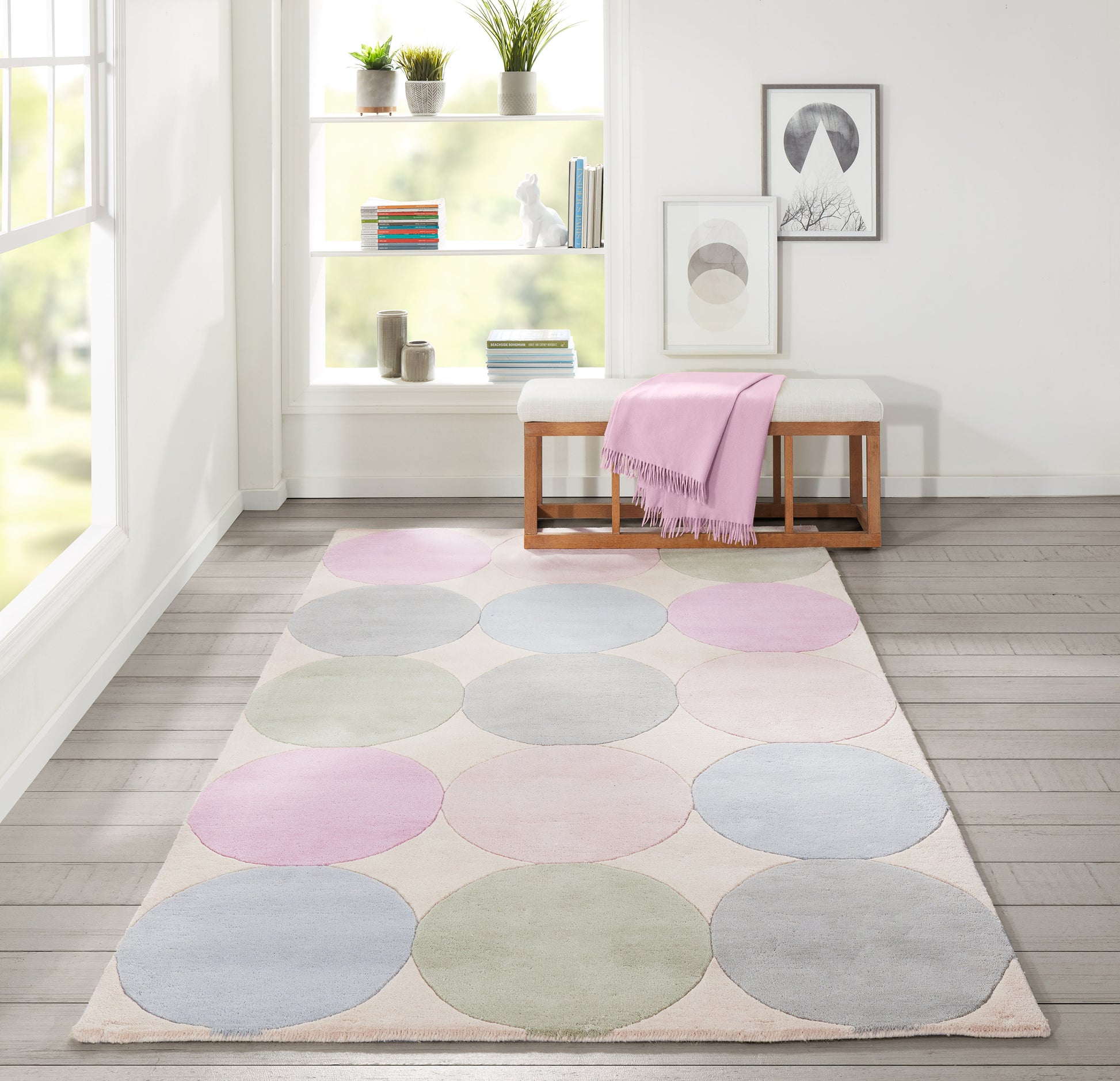 Pastel circle rug with pink, blue and green circles on beige background in a bright modern living room.