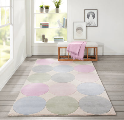 Pastel circle rug with pink, blue and green circles on beige background in a bright modern living room.