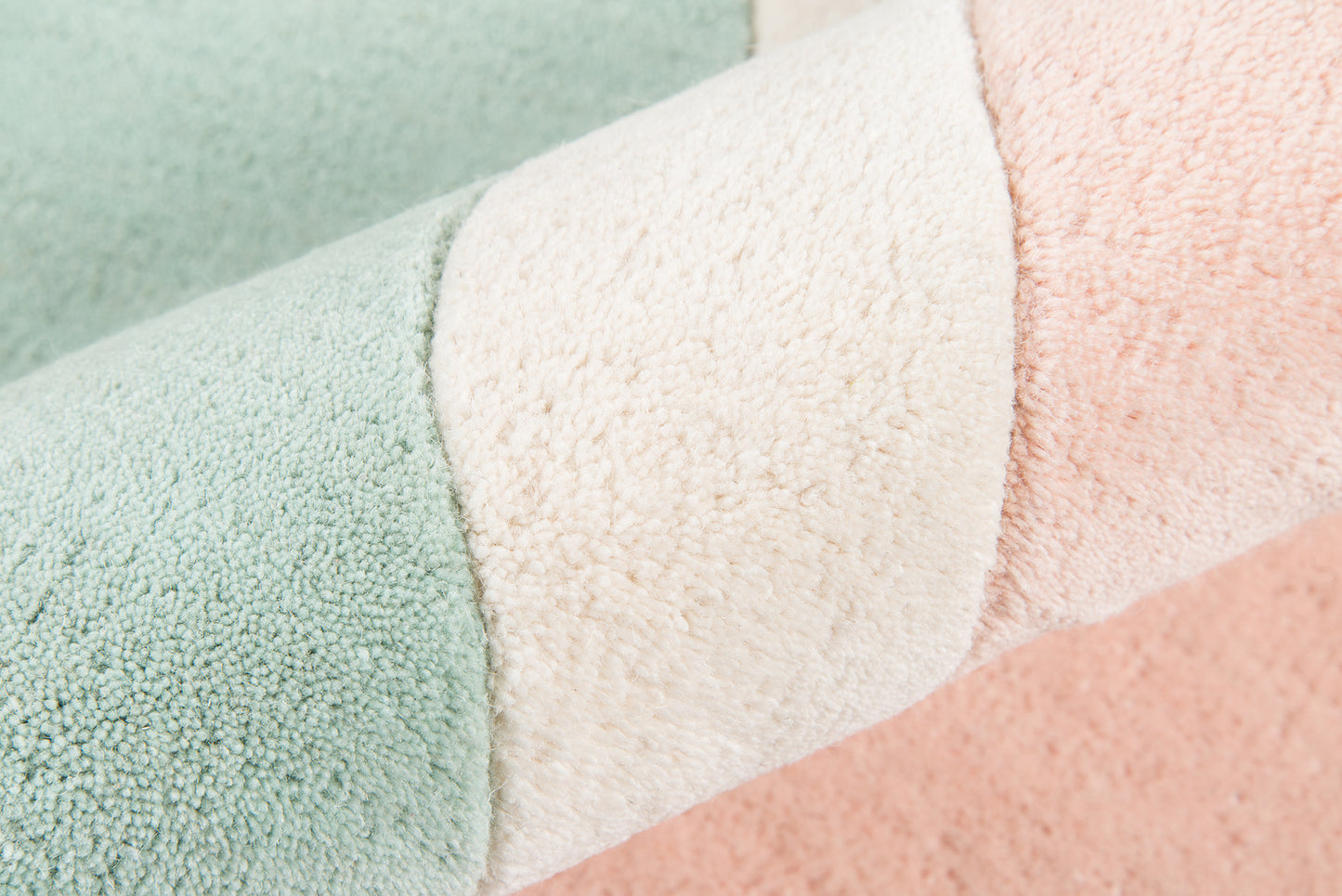 Pastel striped rug in mint, cream, and peach; soft plush texture.