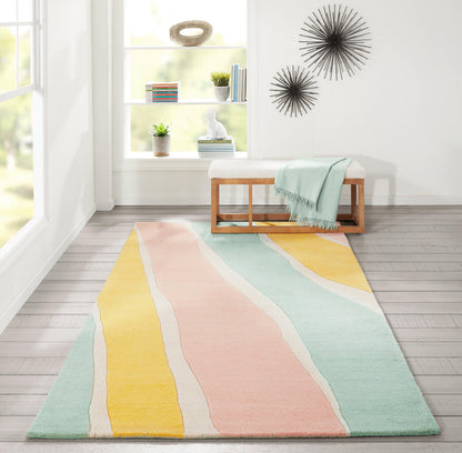 Pastel striped rug with wavy blocks of peach, pink, yellow, mint and teal in a bright living room.