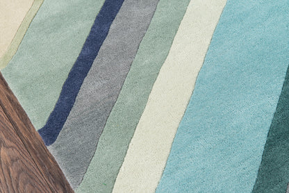 Colorful striped area rug with diagonal bands in blue, teal, green, beige on wood floor.