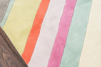 Pastel striped rug with diagonal bands of yellow, orange, cream, pink, lavender and mint beside a wooden edge.