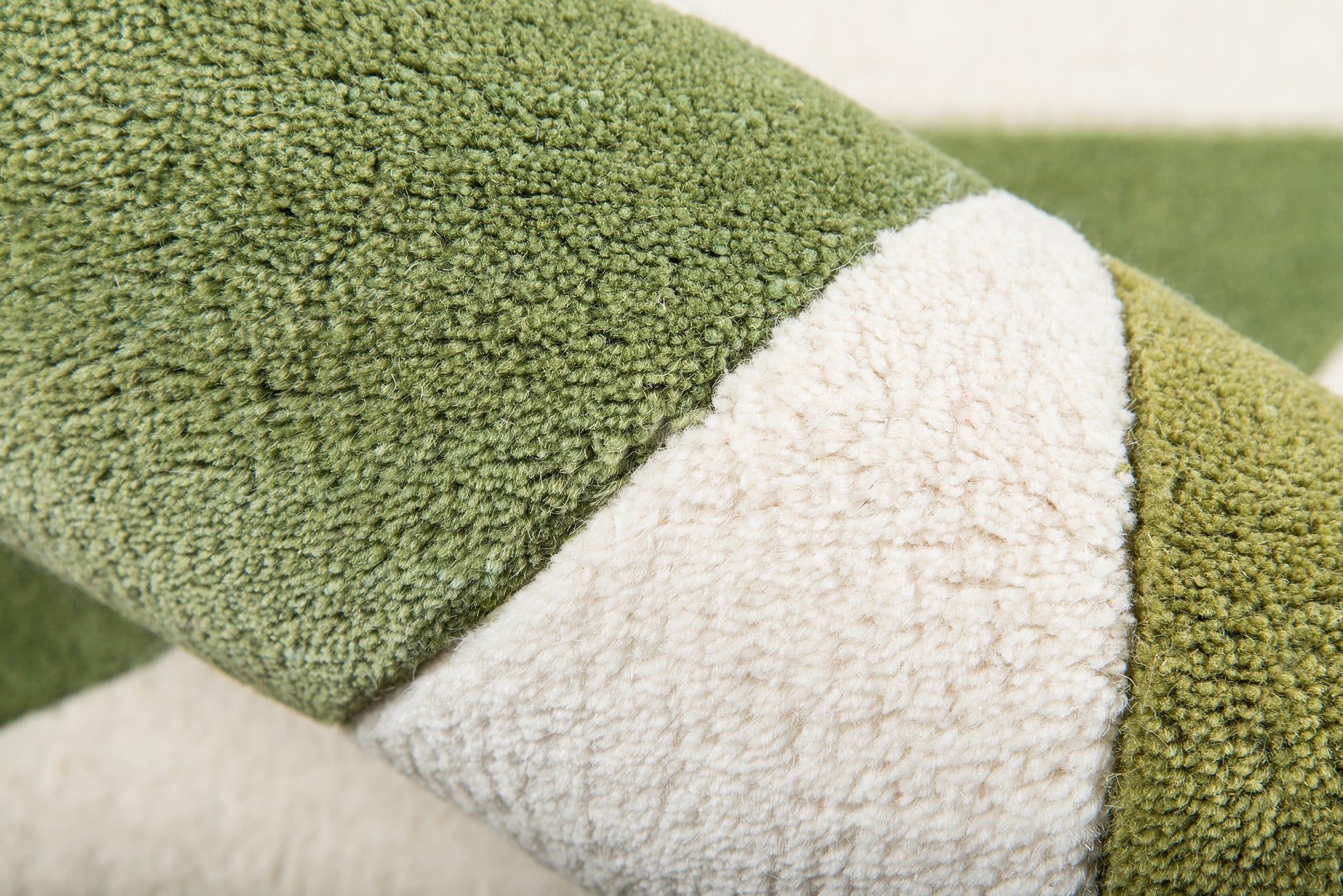 Close-up of olive green and ivory boucle rug with thick loop pile.