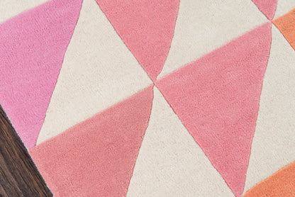 Geometric triangle rug in pink, peach and cream tones with a dark wood floor edge.