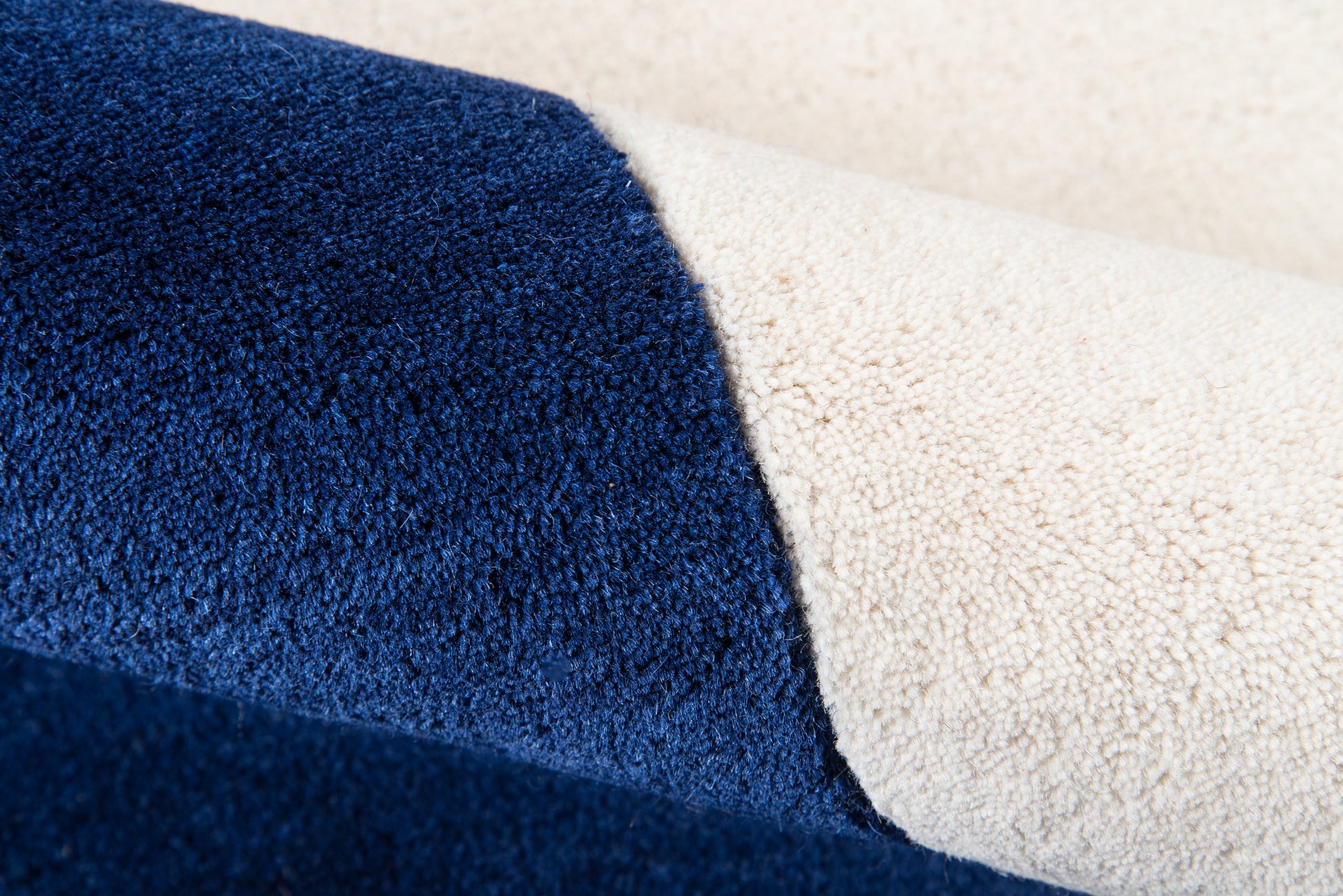 Two-tone navy blue and cream rug with looped pile texture.