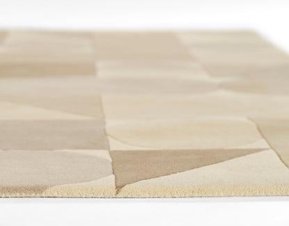 Beige patchwork rug with alternating light tan and cream squares, soft textile with a fringed edge.