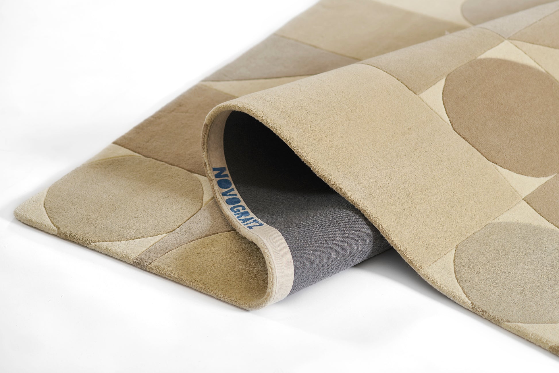 Beige yoga mat with taupe circular pattern, microfiber top, rolled to show gray underside, DELMA branding.