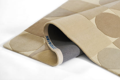 Beige circular-pattern rug rolled at edge, taupe circles on a soft textile for a modern floor mat.