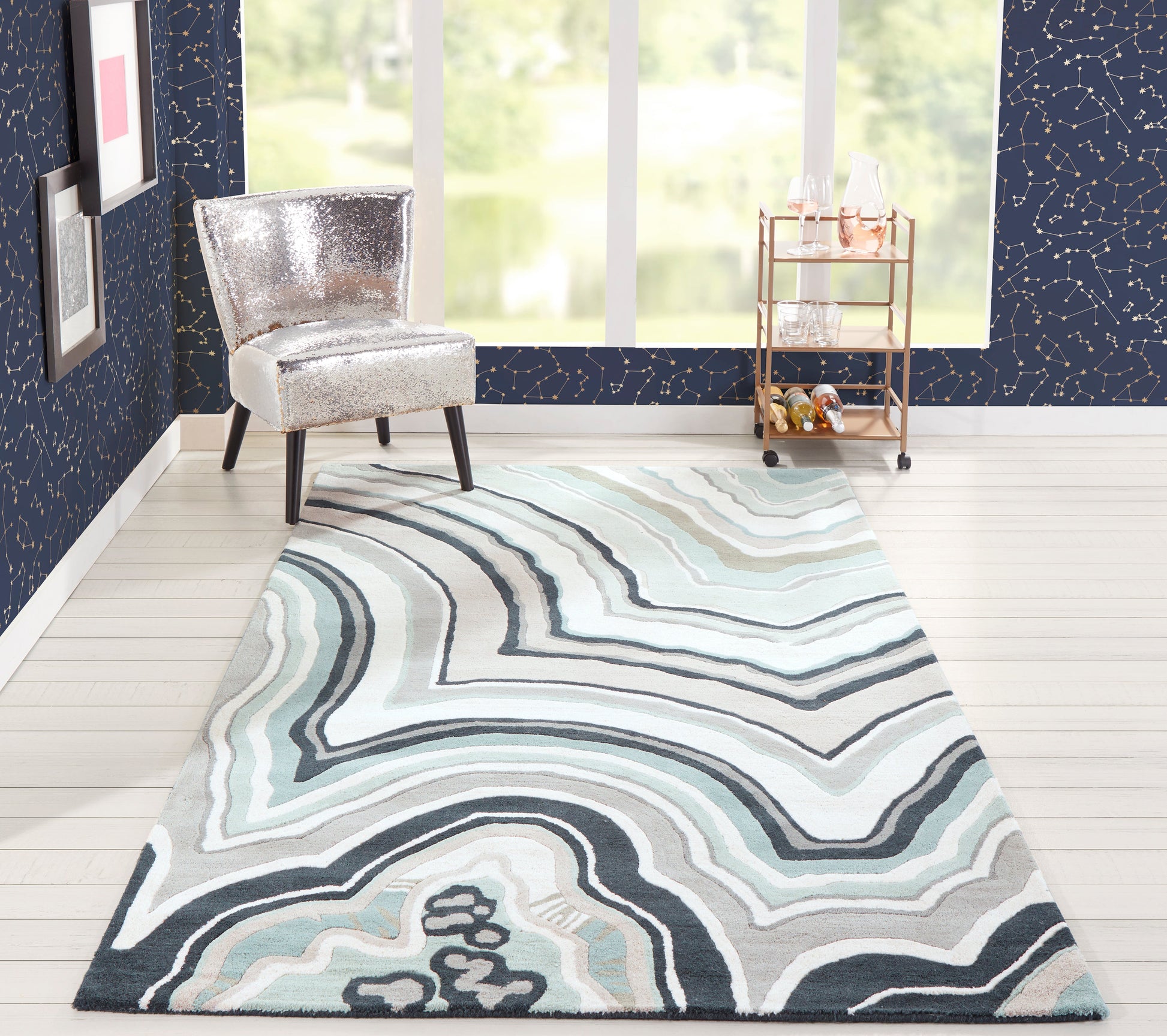 Rectangular rug with swirling blue, teal and gray marble-patterned lines in a modern living room.