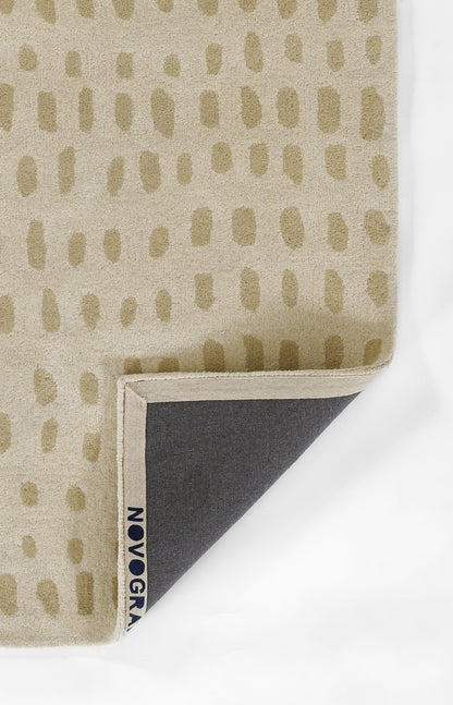Beige fabric with tan oval dot pattern, folded corner reveals navy underside and small blue edge tag.