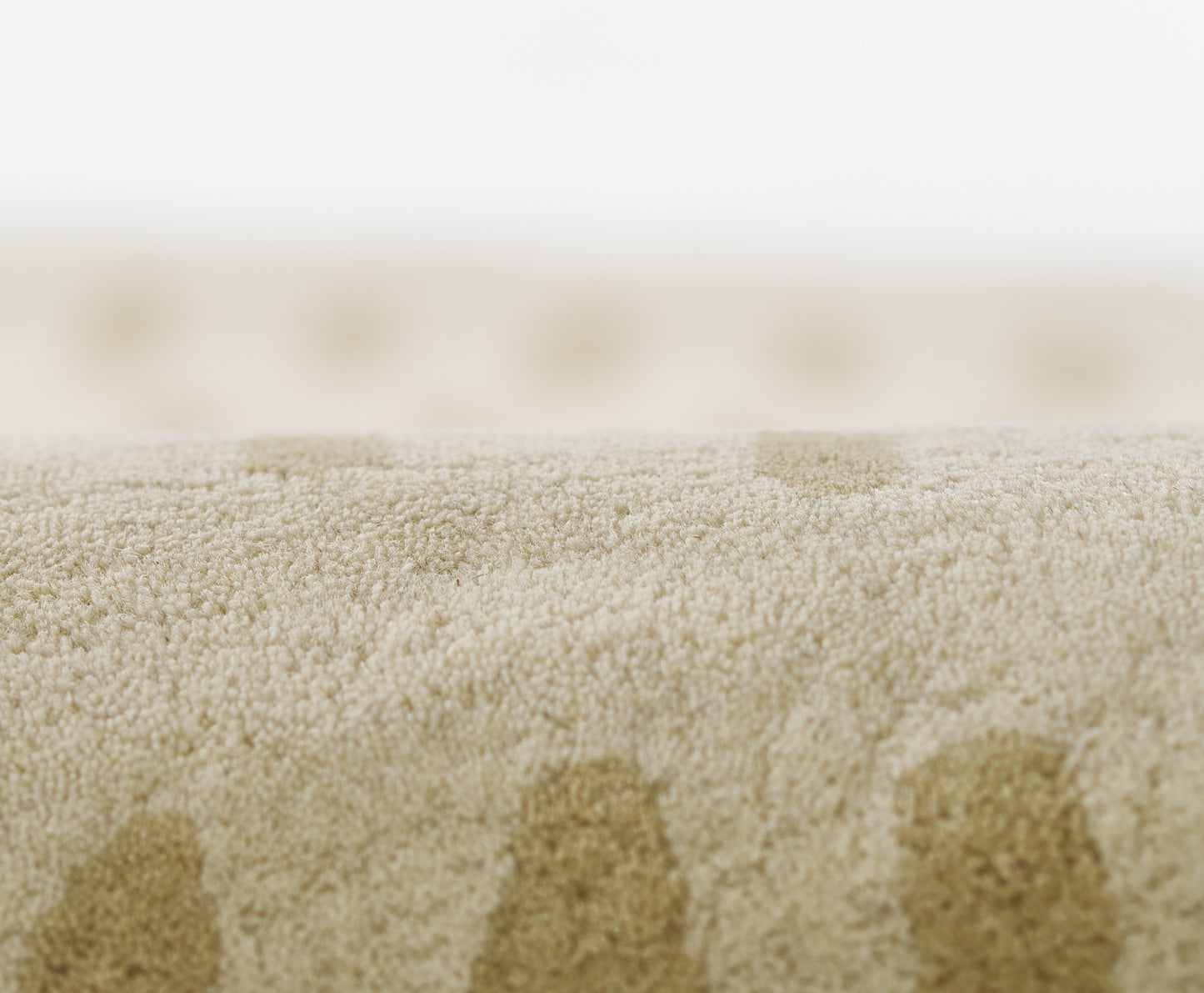 Beige plush rug with soft high-pile fibers and subtle circular darker dots.