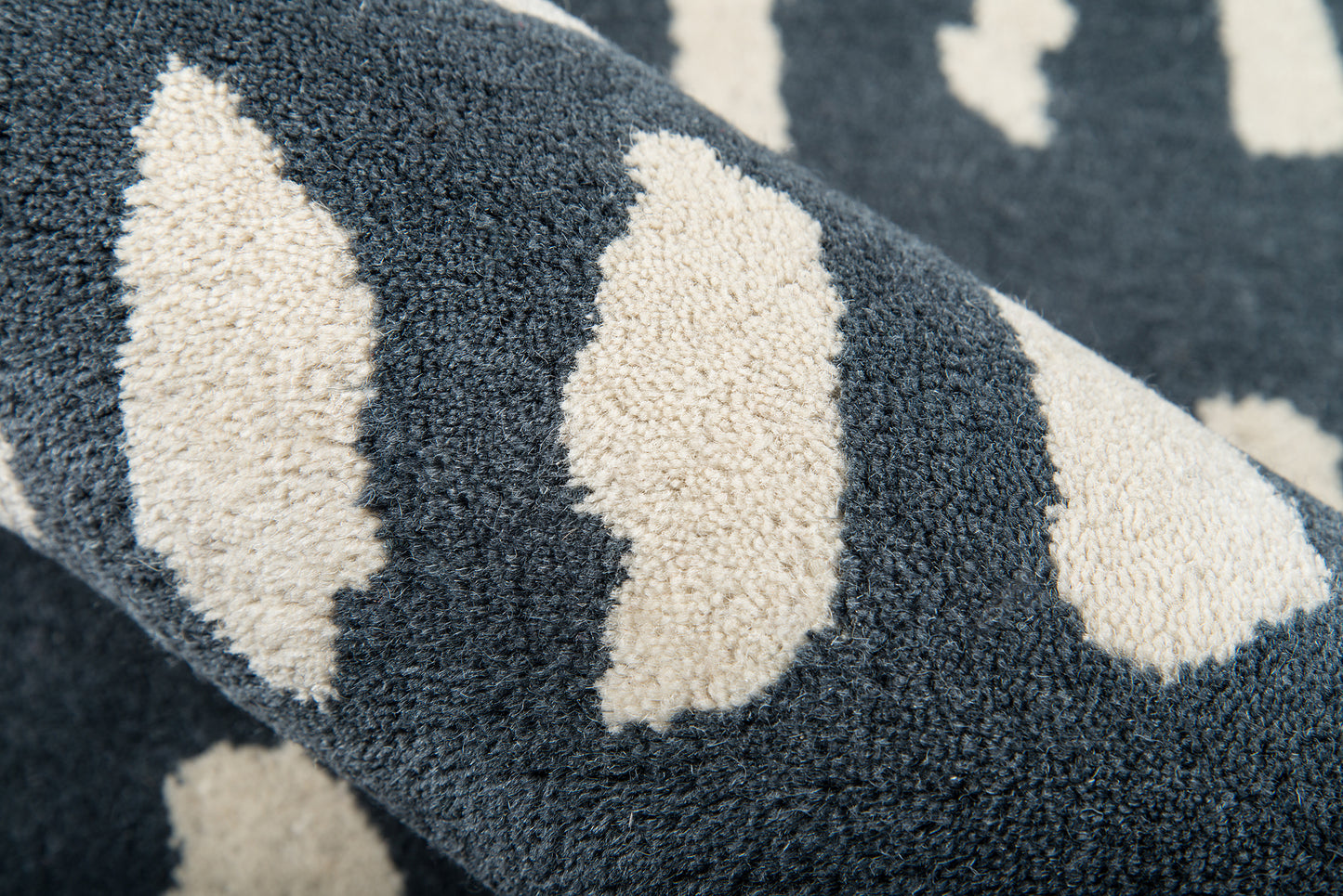 Navy blue plush rug with cream diamond shapes; soft shaggy pile and cozy look.