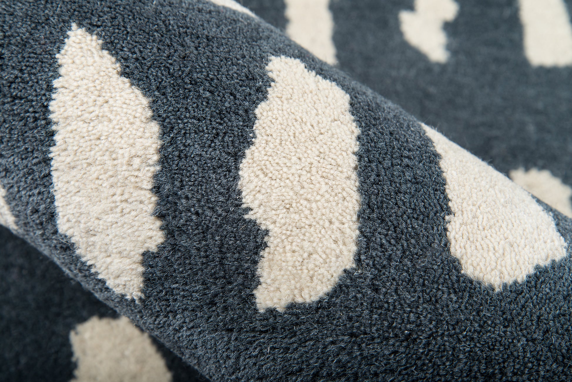 Navy blue plush rug with cream diamond shapes; soft shaggy pile and cozy look.