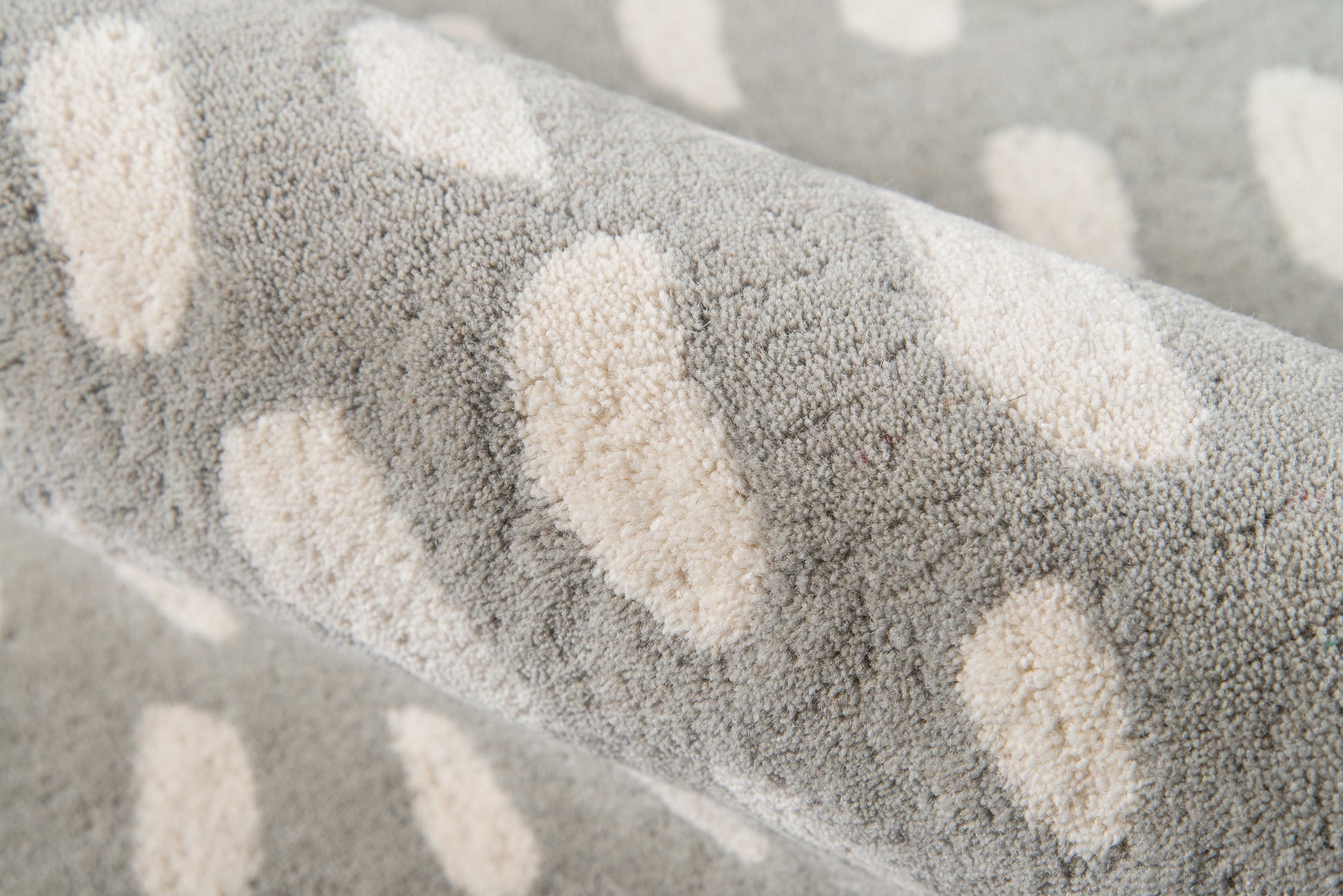 Soft gray rug with cream oval spots; suitable for living room or hallway.
