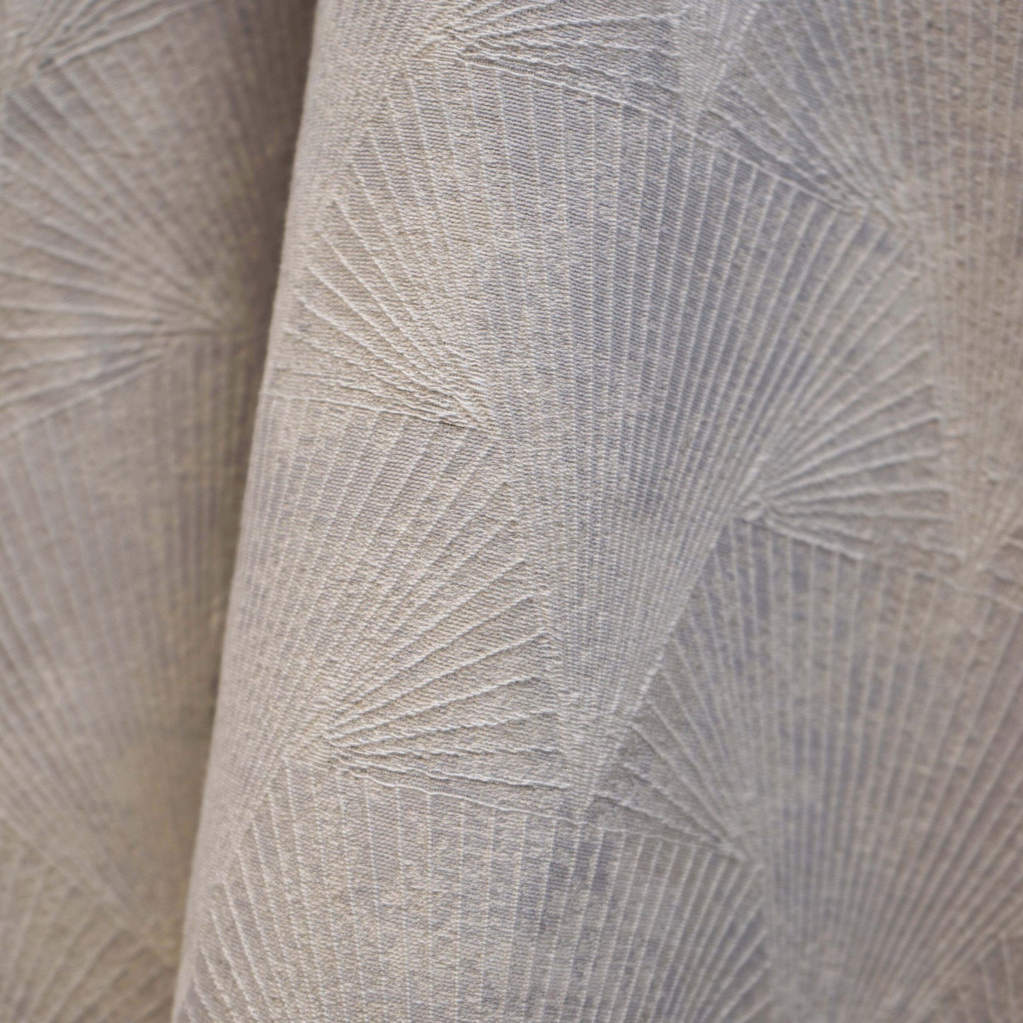 Taupe beige upholstery fabric with raised sunburst geometric pattern; soft woven texture.
