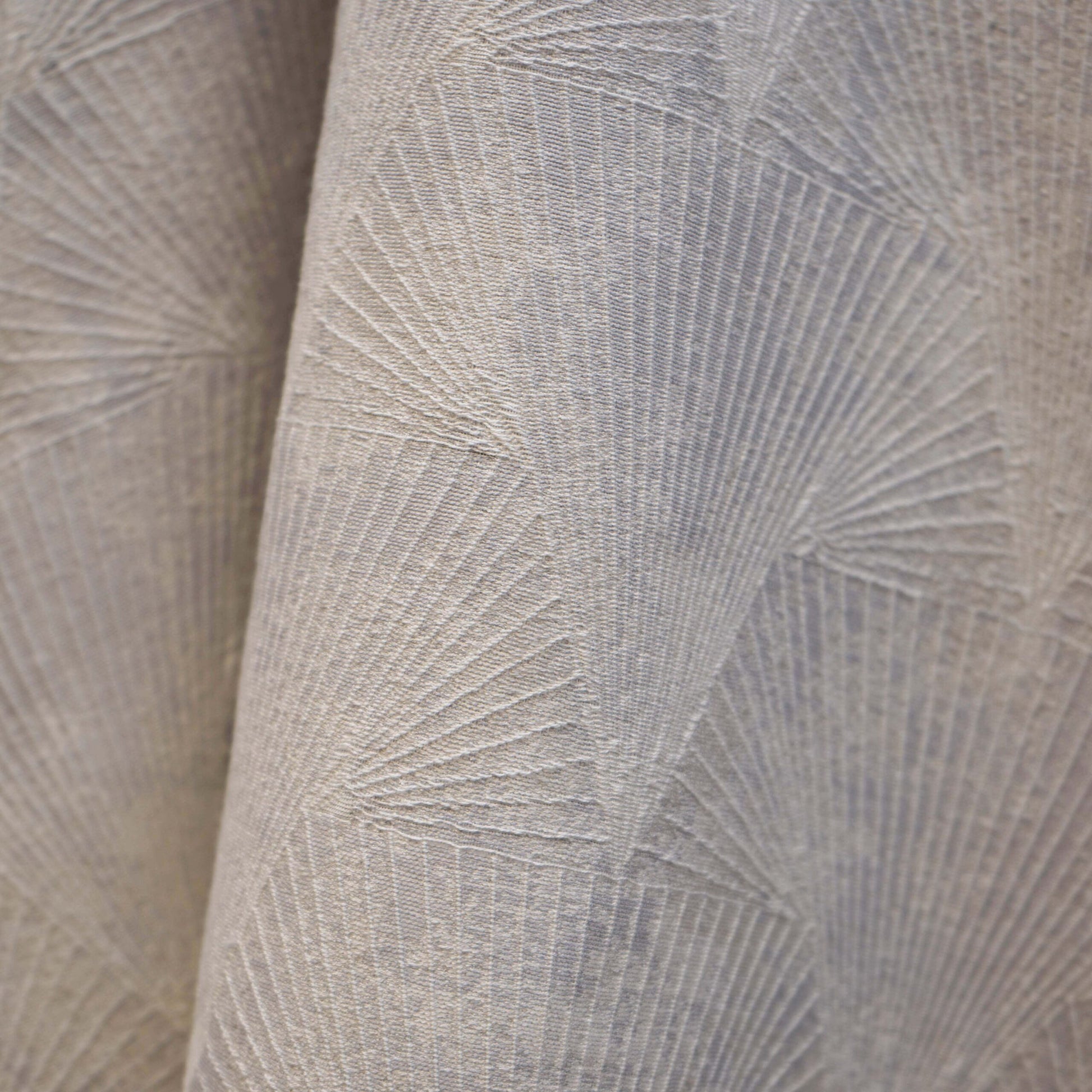 Taupe beige upholstery fabric with raised sunburst geometric pattern; soft woven texture.