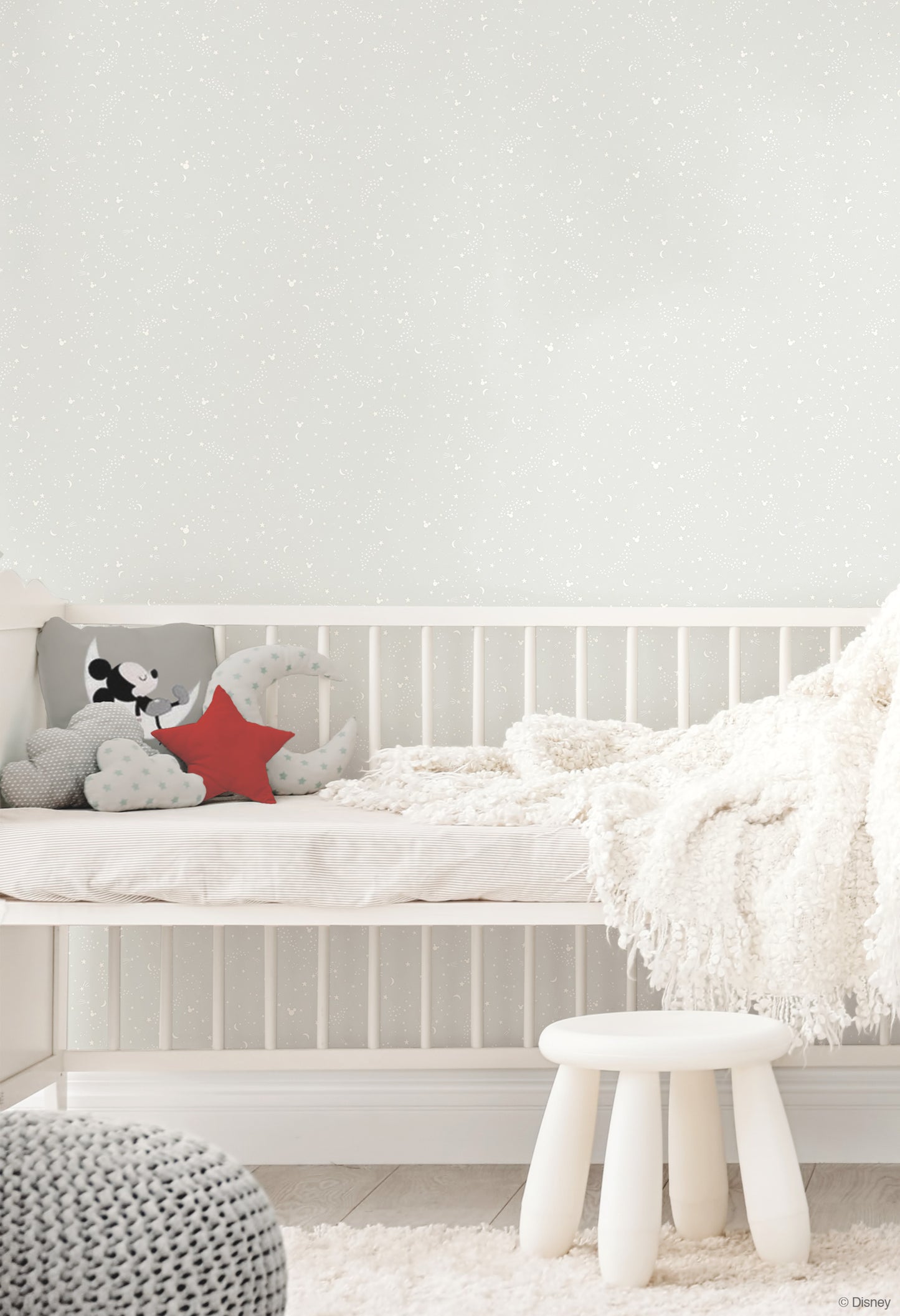 Grey wallpaper in a nursery featuring a Mickey Mouse star pattern on the wall.