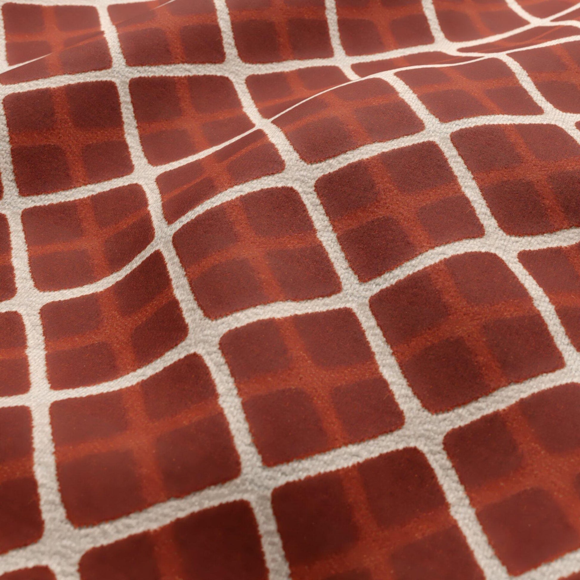 Close-up of orange and cream velvet fabric texture with a geometric diamond pattern.