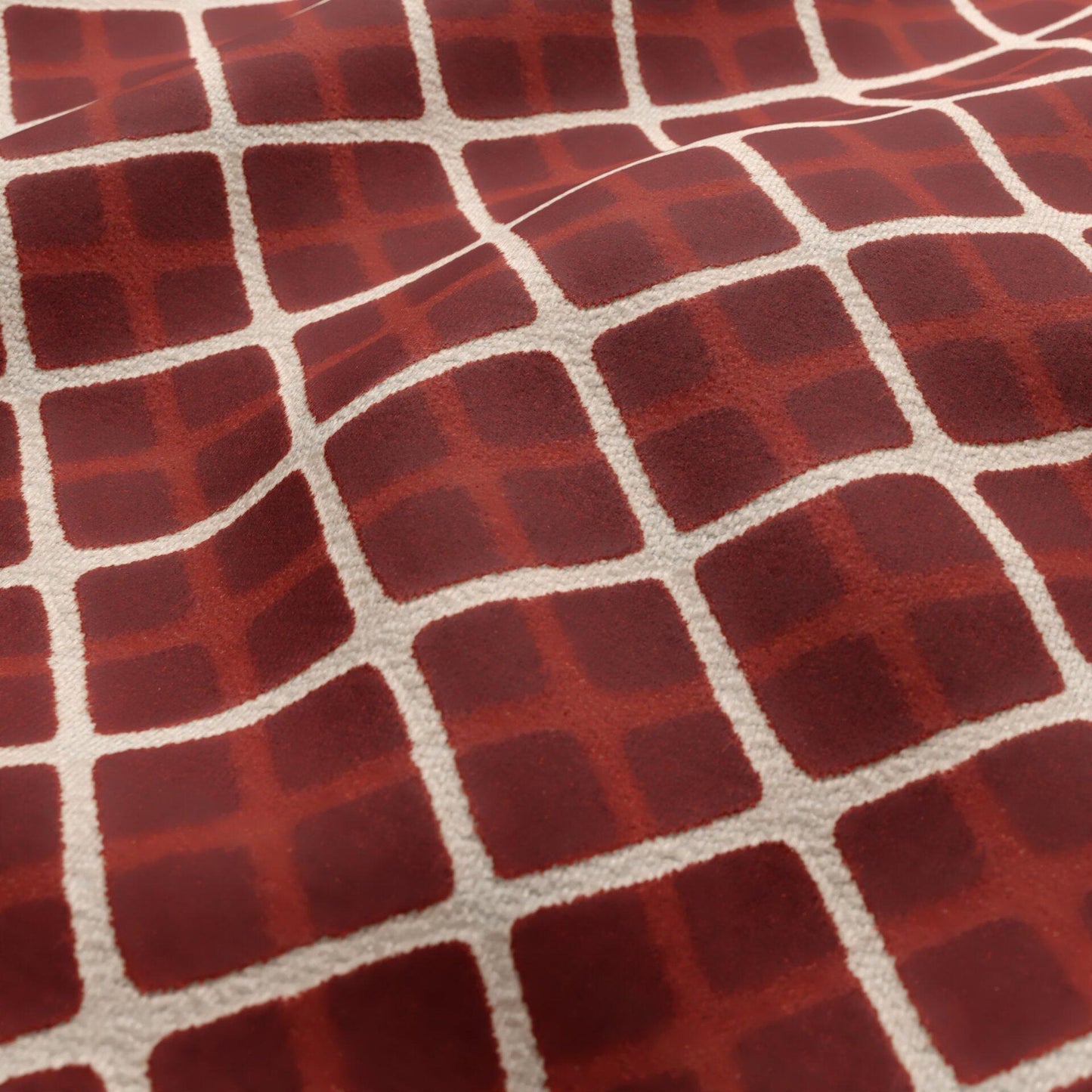 Red diamond-grid textile with cream lines; plush velvet fabric in warm burgundy tones.