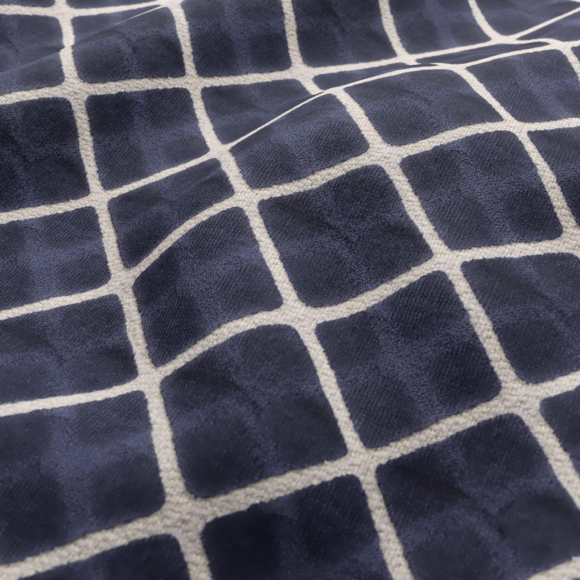 Navy blue velvet fabric with a cream geometric diamond pattern.