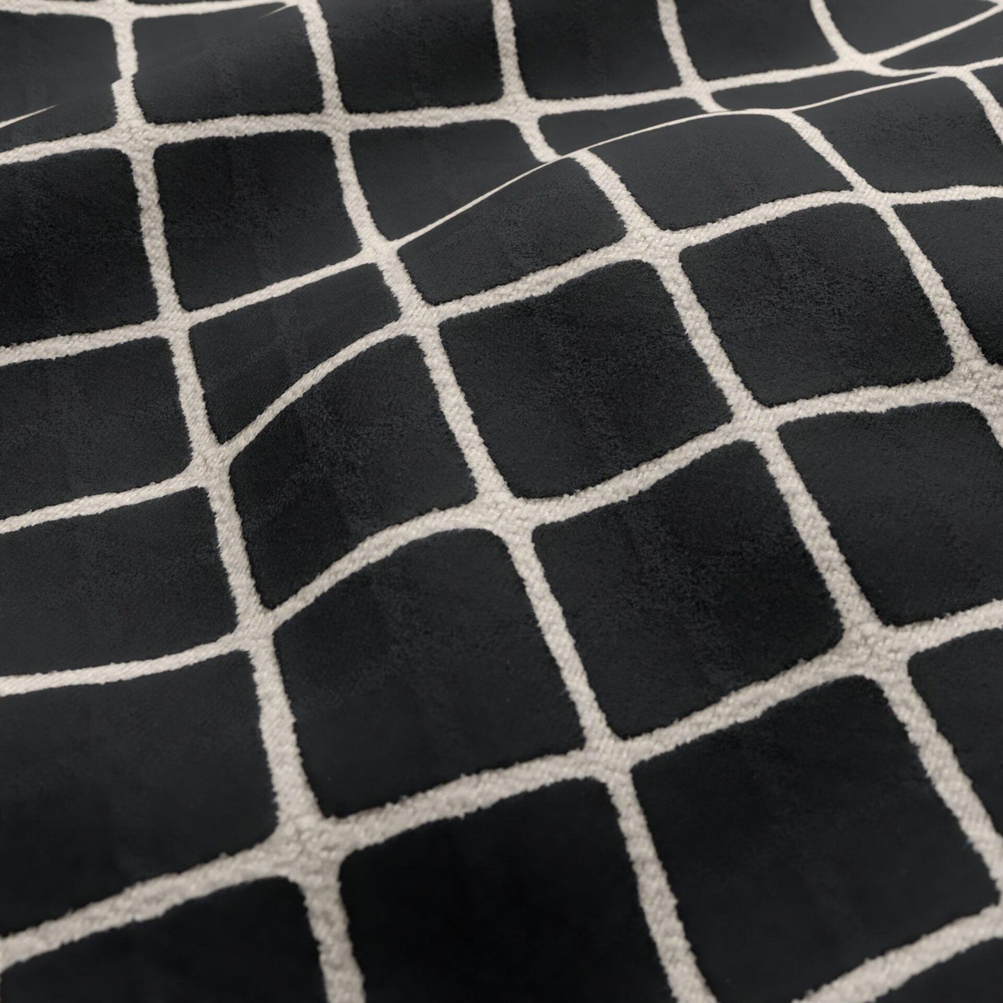 Black velvet fabric texture with a cream geometric diamond-grid pattern.