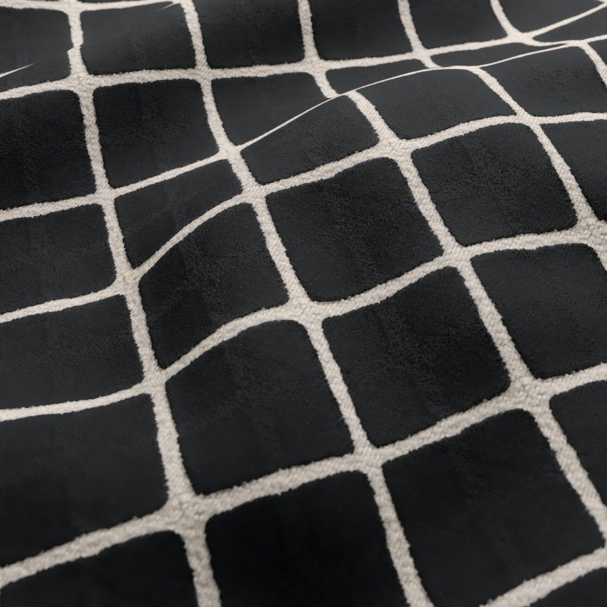Black velvet fabric texture with a cream geometric diamond-grid pattern.
