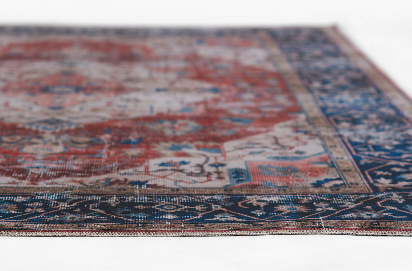 Persian-style area rug with red field, blue border, and intricate floral motifs for living room decor.