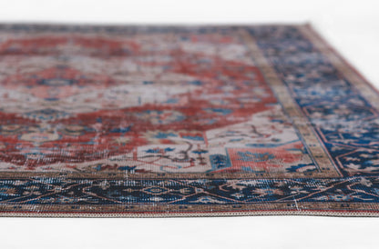 Persian-style area rug with red field, blue border, and intricate floral motifs for living room decor.