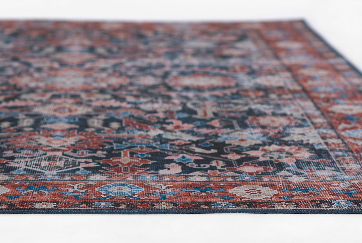 Persian-style oriental rug with navy, red and ivory floral motifs; rectangular, decorative area rug for living room.