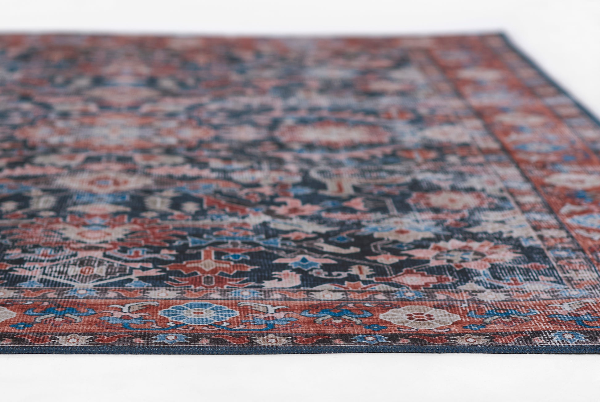 Persian-style oriental rug with navy, red and ivory floral motifs; rectangular, decorative area rug for living room.
