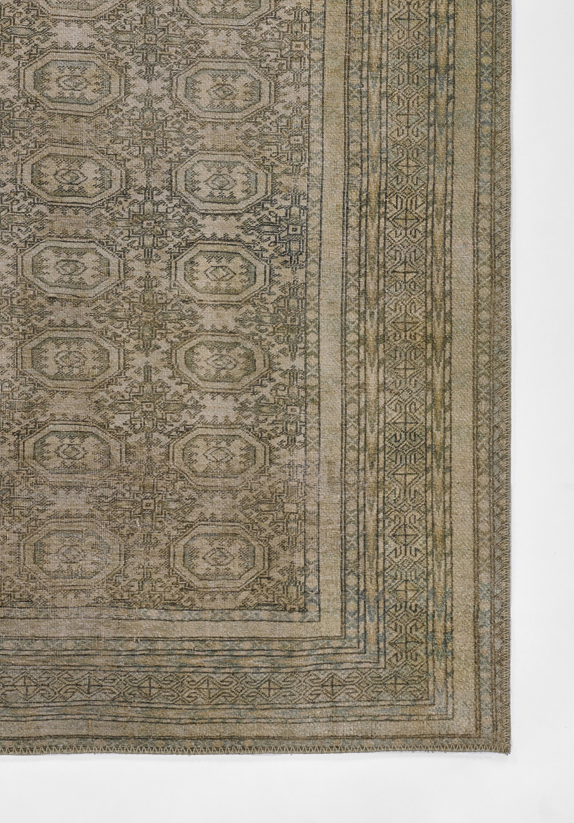 Rectangular woven rug with repeating octagonal medallions in muted olive, taupe, and gray; ornate border pattern.