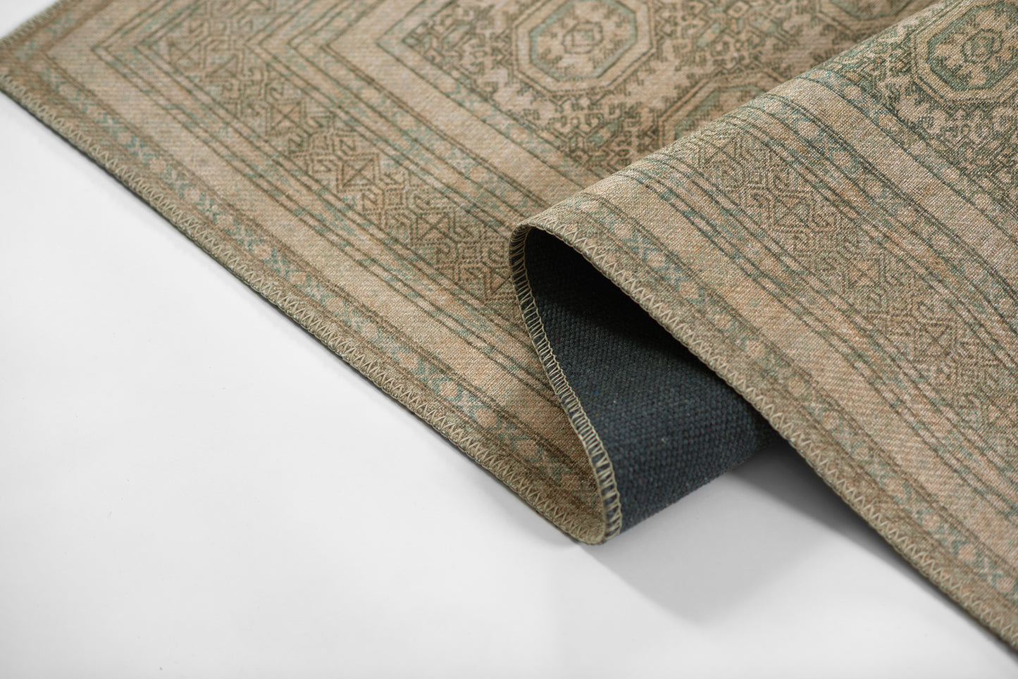 Beige oriental area rug with sage-green geometric medallions, woven texture, rolled edge, neutral decor for floors.