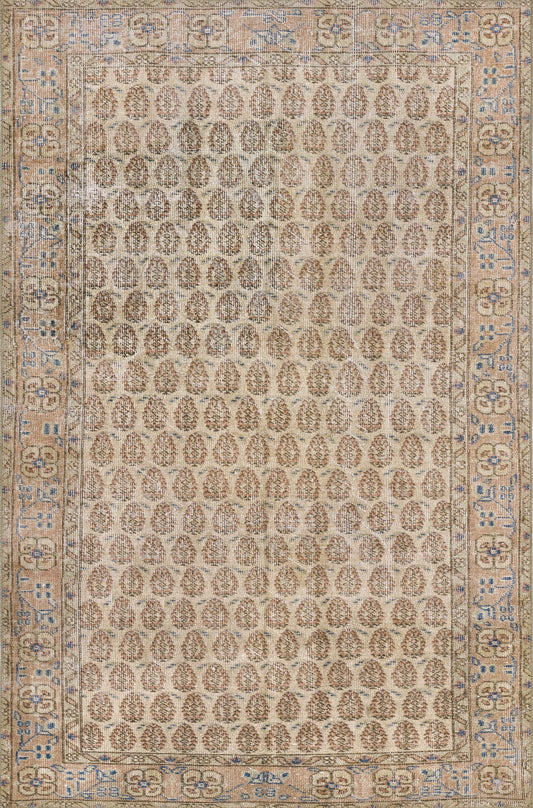 Beige oriental rug with dense repeating brown oval motifs; blue-tinted floral border, rectangular living-room area rug.