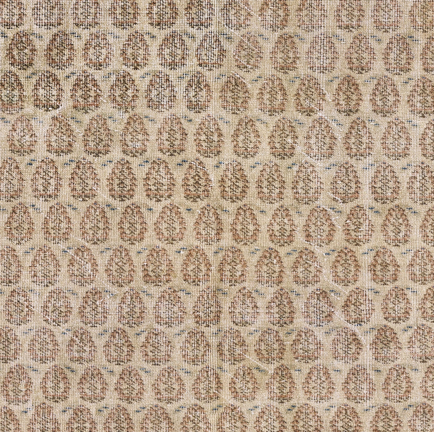 Beige woven rug with repeating brown oval medallions; textured, warm neutral floor covering.