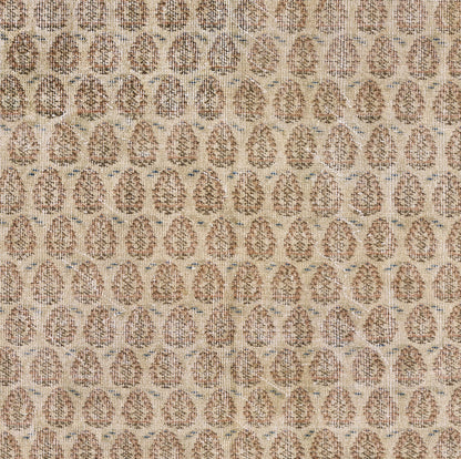 Beige woven rug with repeating brown oval medallions; textured, warm neutral floor covering.