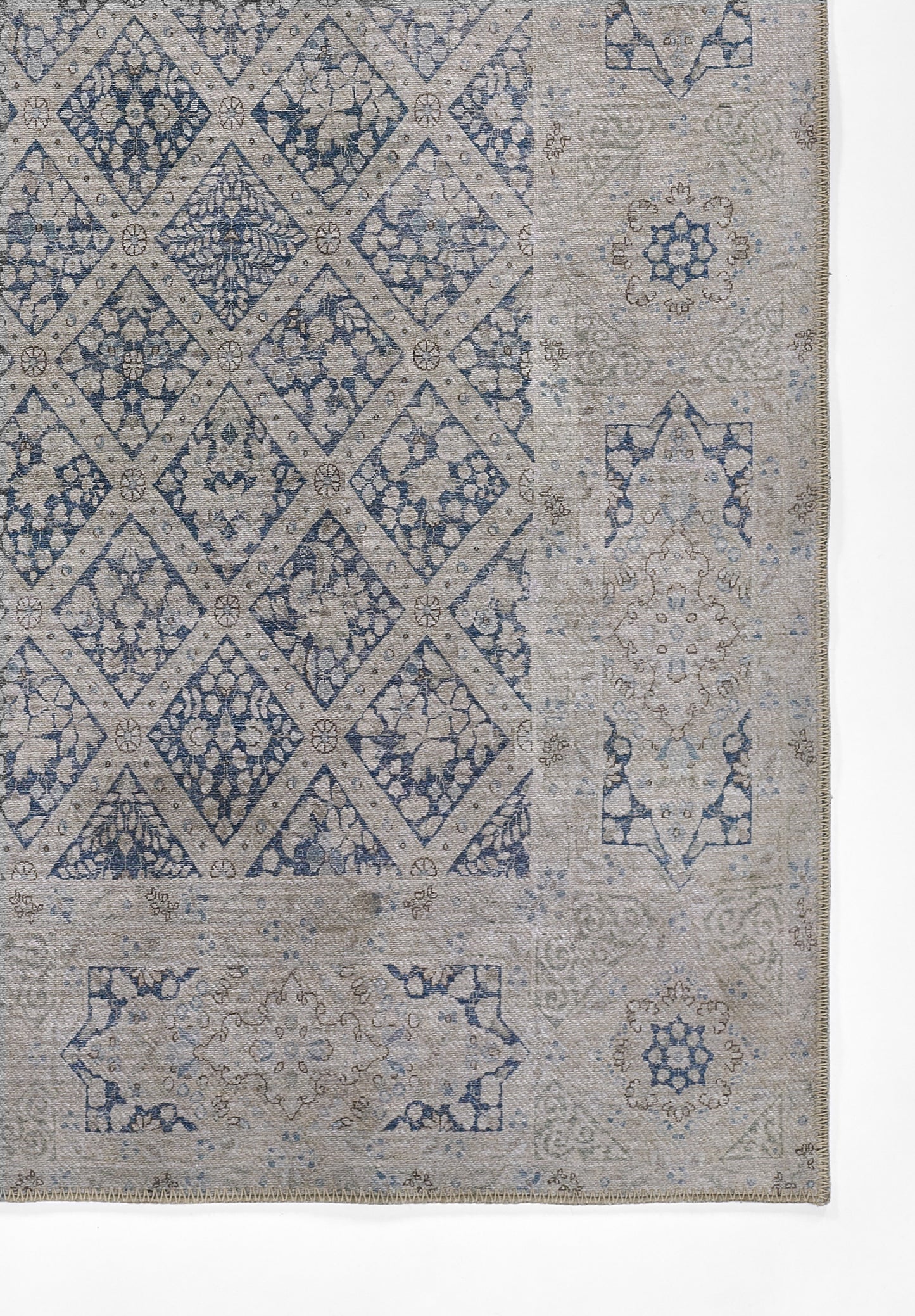 Blue and beige rug featuring diamond lattice center with floral motifs and ornate border.