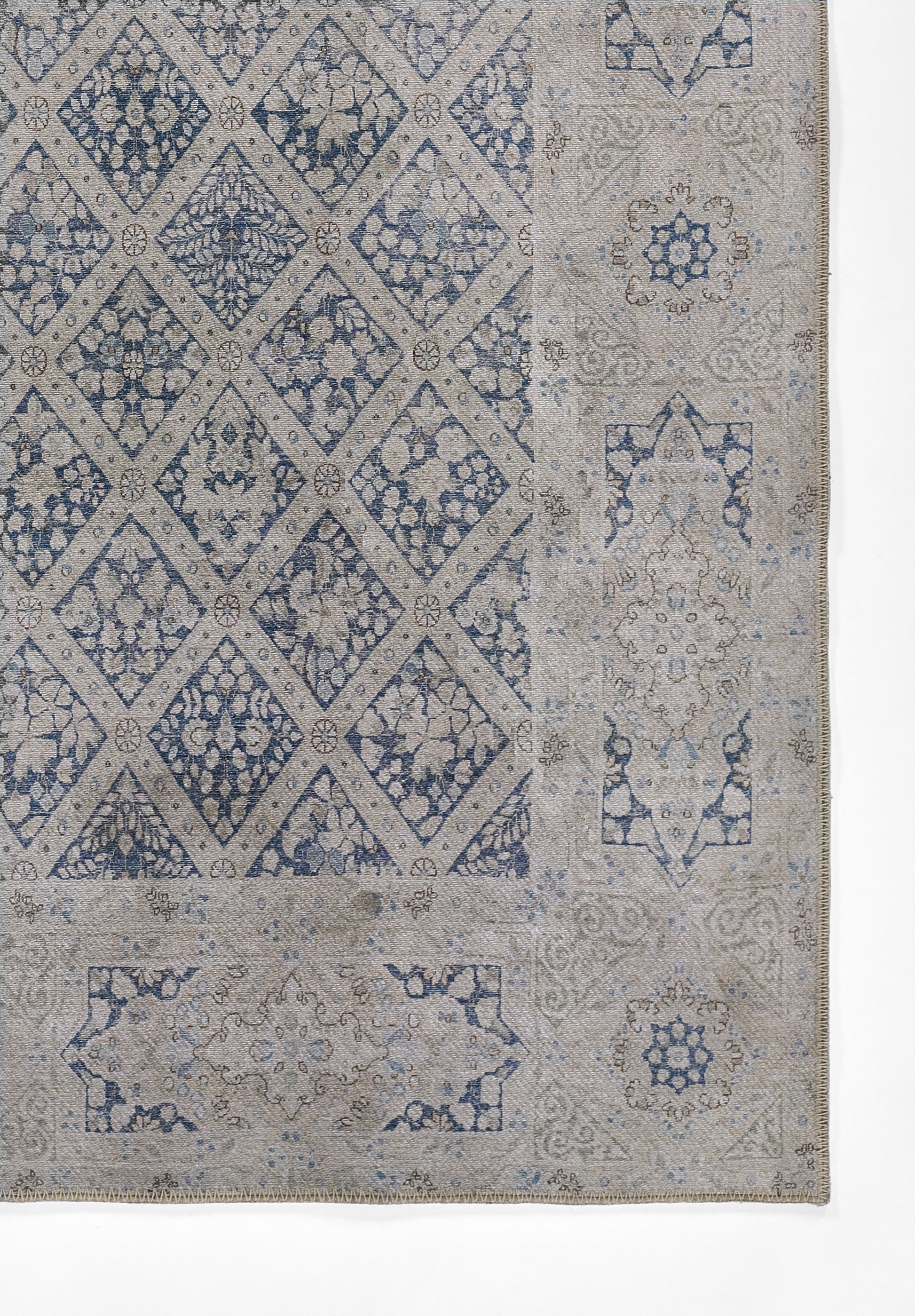 Blue and beige rug featuring diamond lattice center with floral motifs and ornate border.
