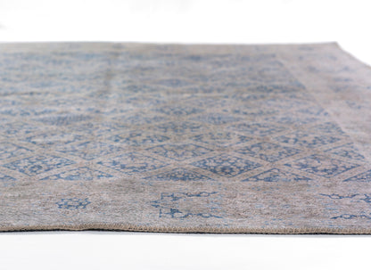 Rectangular rug with blue geometric diamond motifs on a beige-gray background; low-pile, flat-weave style.